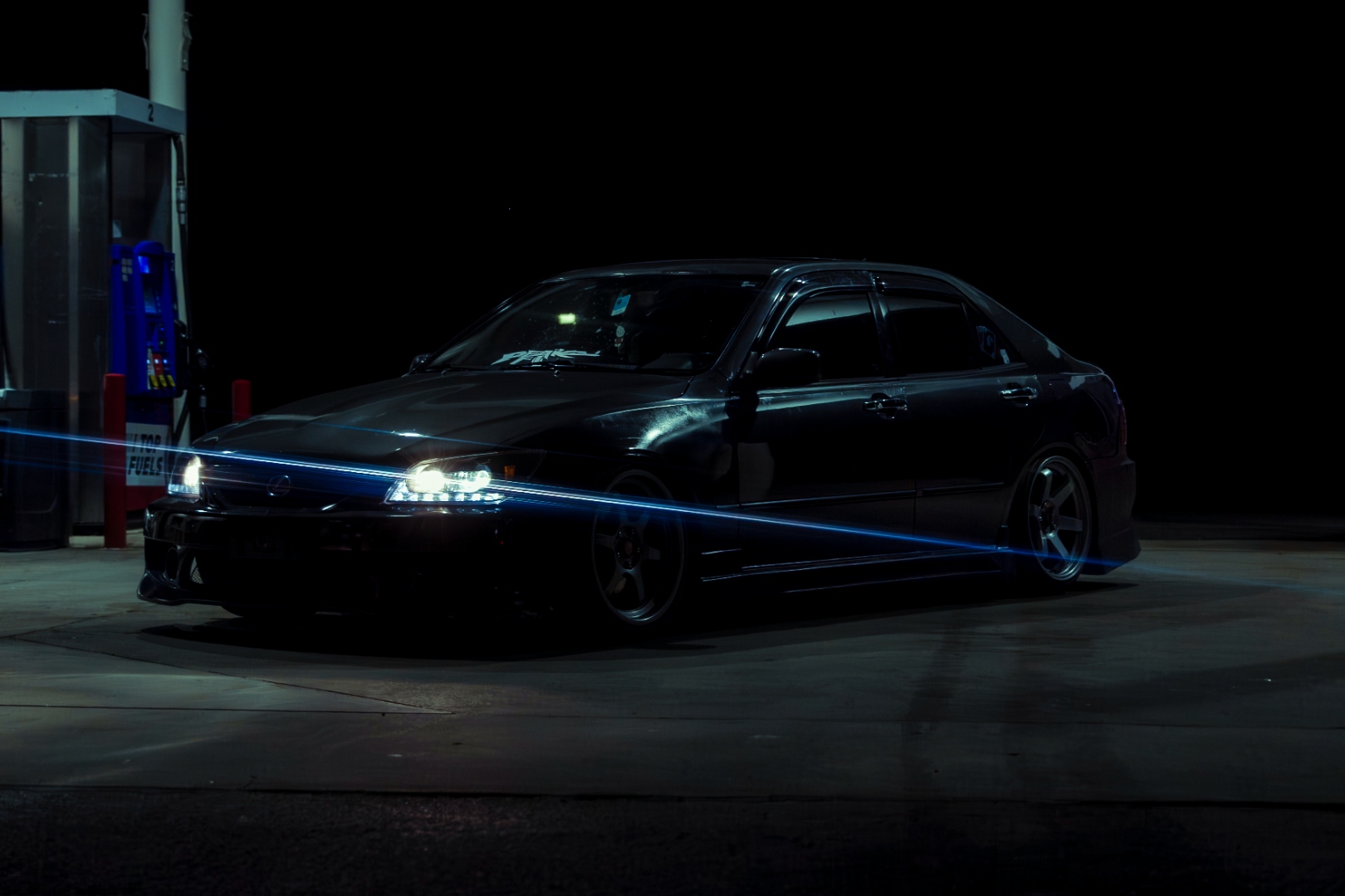 Lexus IS300 with blue light painting at gas station