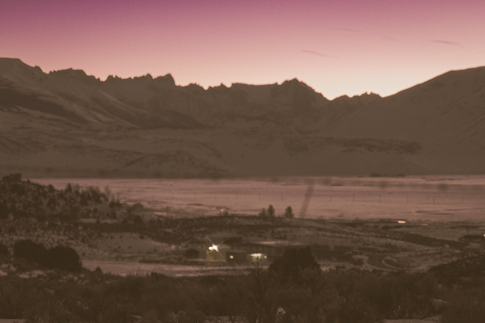 High desert valley at dusk with distant ranch lights