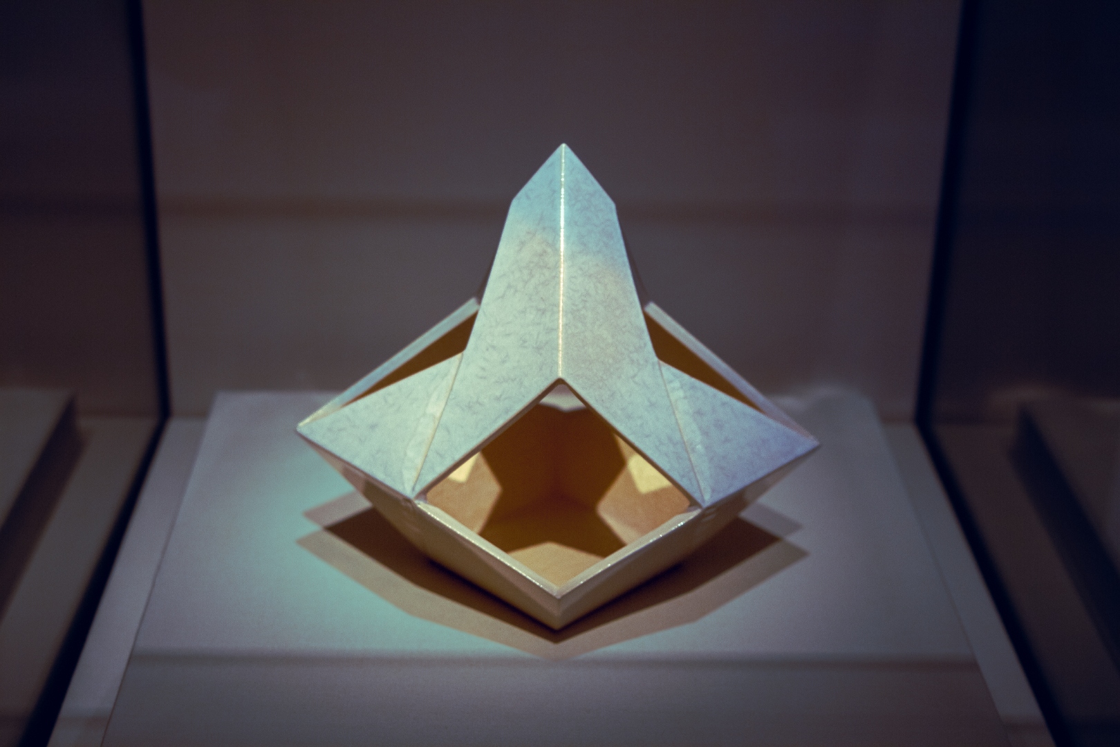 Illuminated origami paper sculpture in museum display