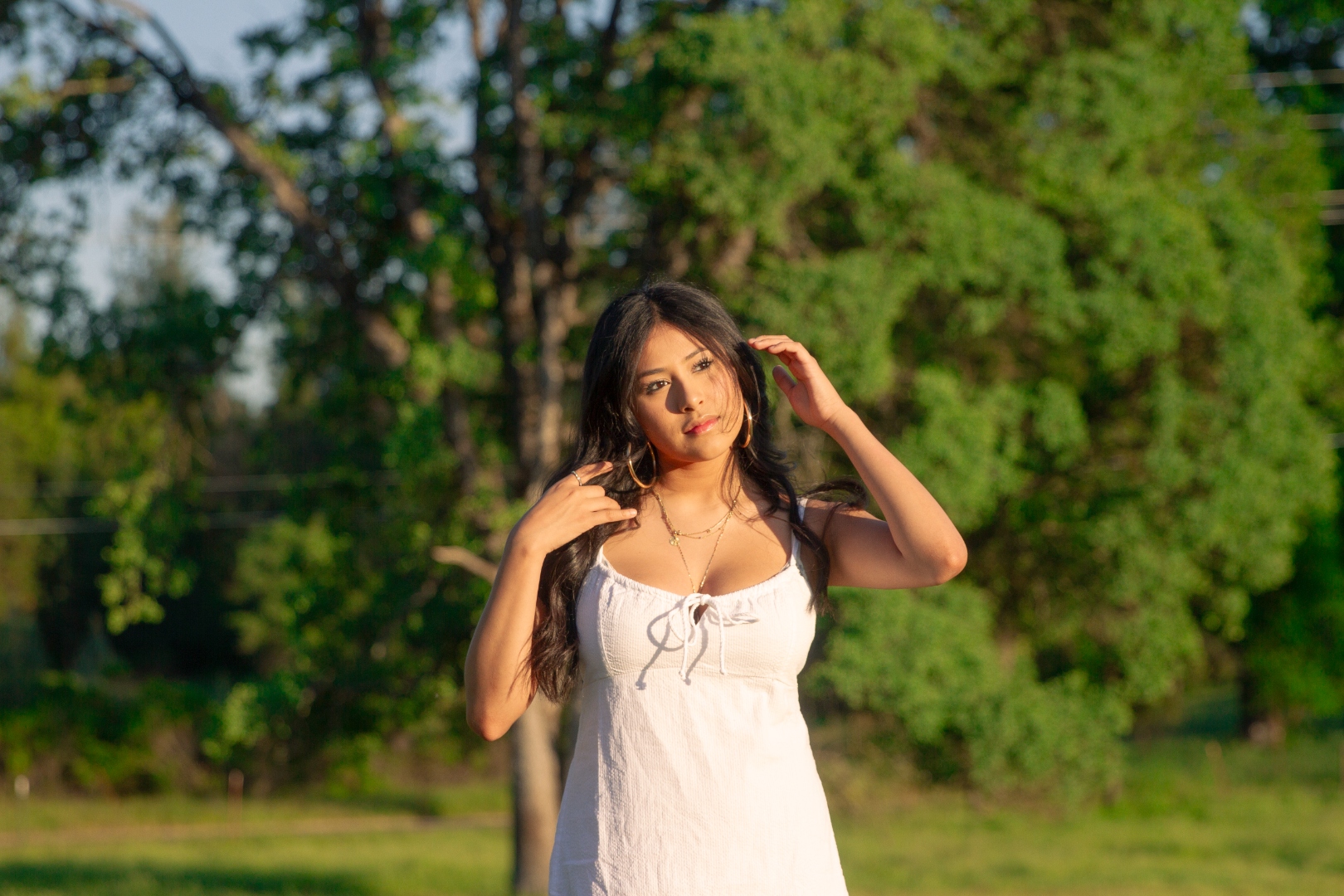 Woman in white dress, hands raised