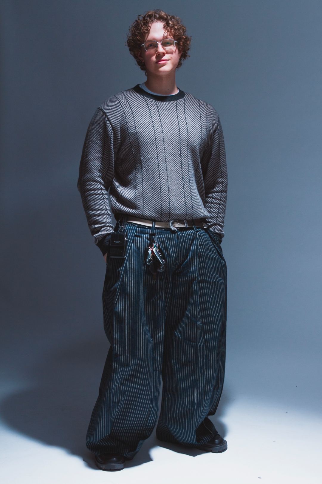 Self-portrait: front-facing studio shot in pinstripe trousers