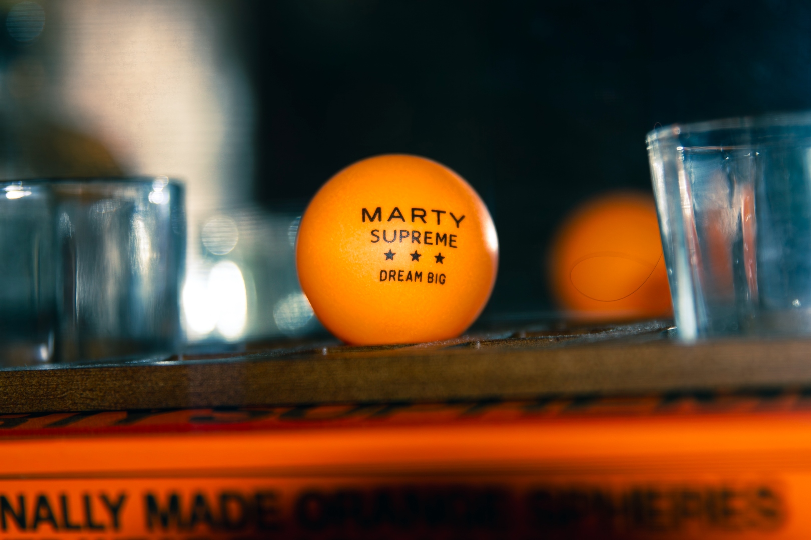 Marty Supreme ping pong balls and shot glasses on wooden tray