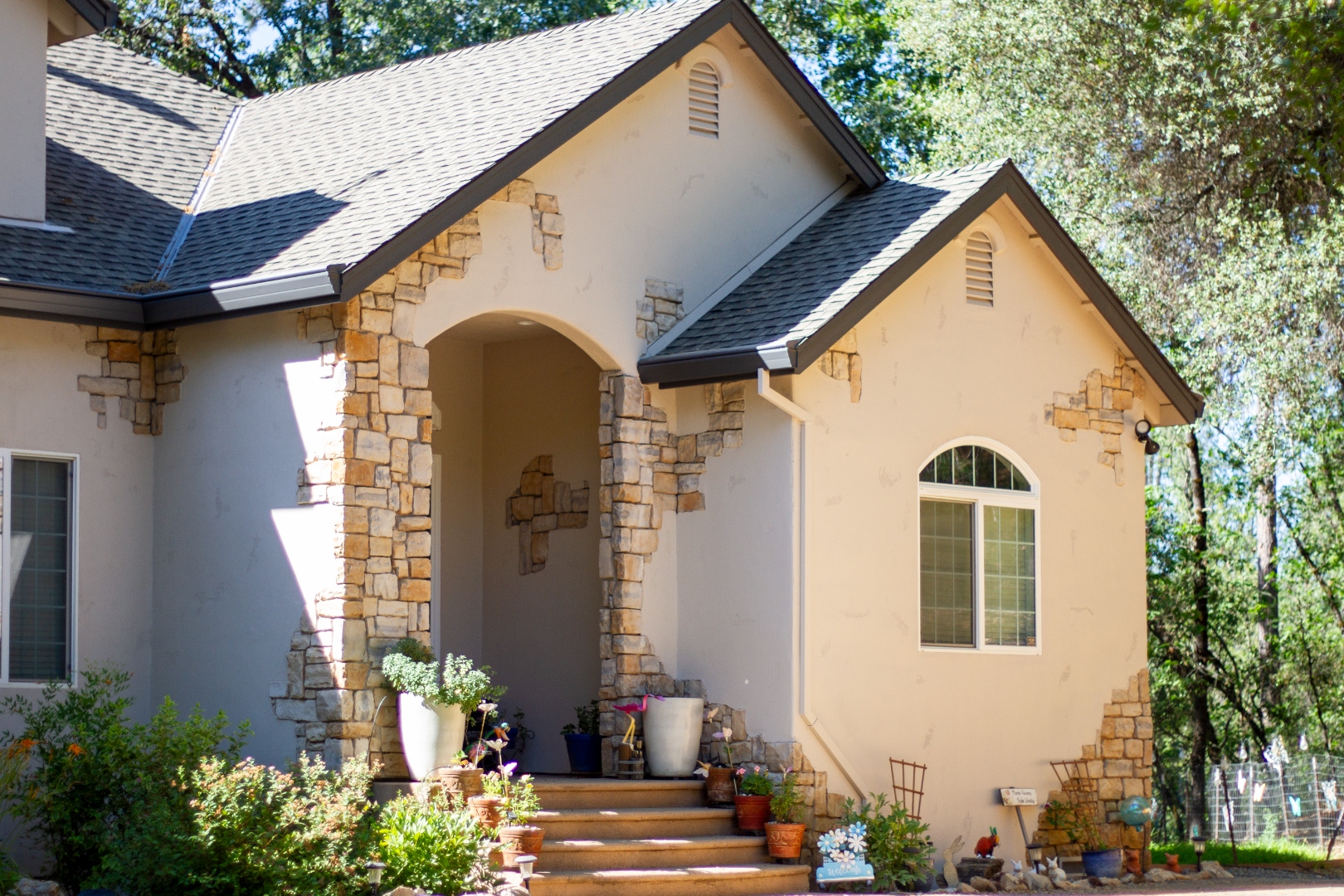 Stone cottage with rustic arch entry and garden