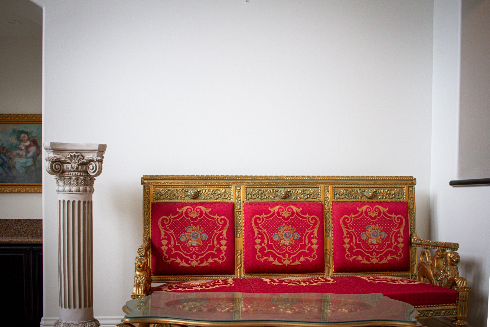 Ornate gold and red French-style settee in formal sitting room