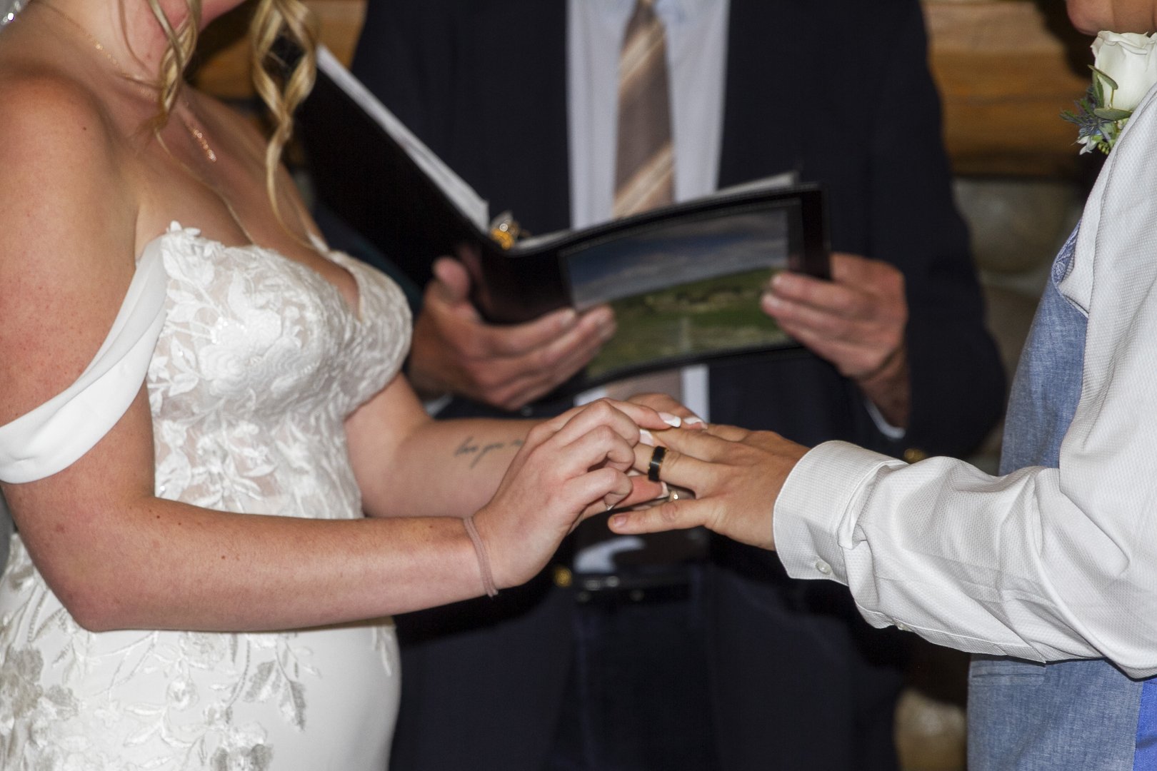 Close up of the ring exchange with the officiant's book in the background